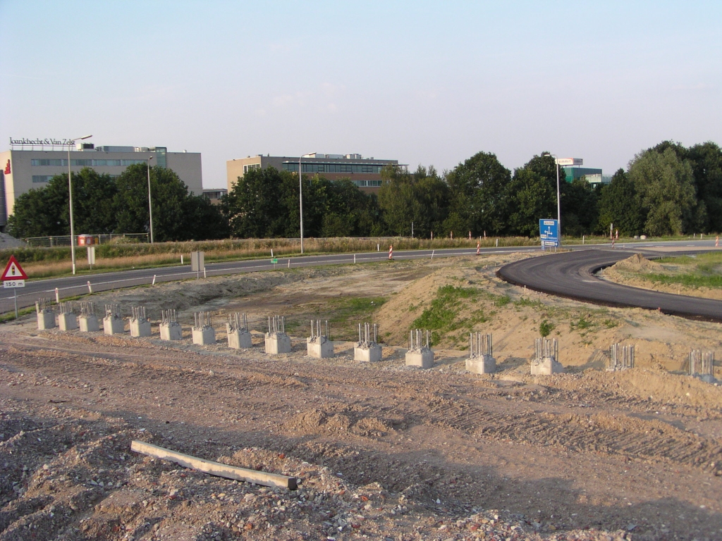 p6170036.jpg - In de aansluiting Veldhoven is de nieuwe afrit vanuit de richting Maastricht al voorzien van een stuk asfalt. Een beduidend krappere boogstraal dan de oude. Op de voorgrond heipalen voor de geluidsschermen langs de parallelbaan.