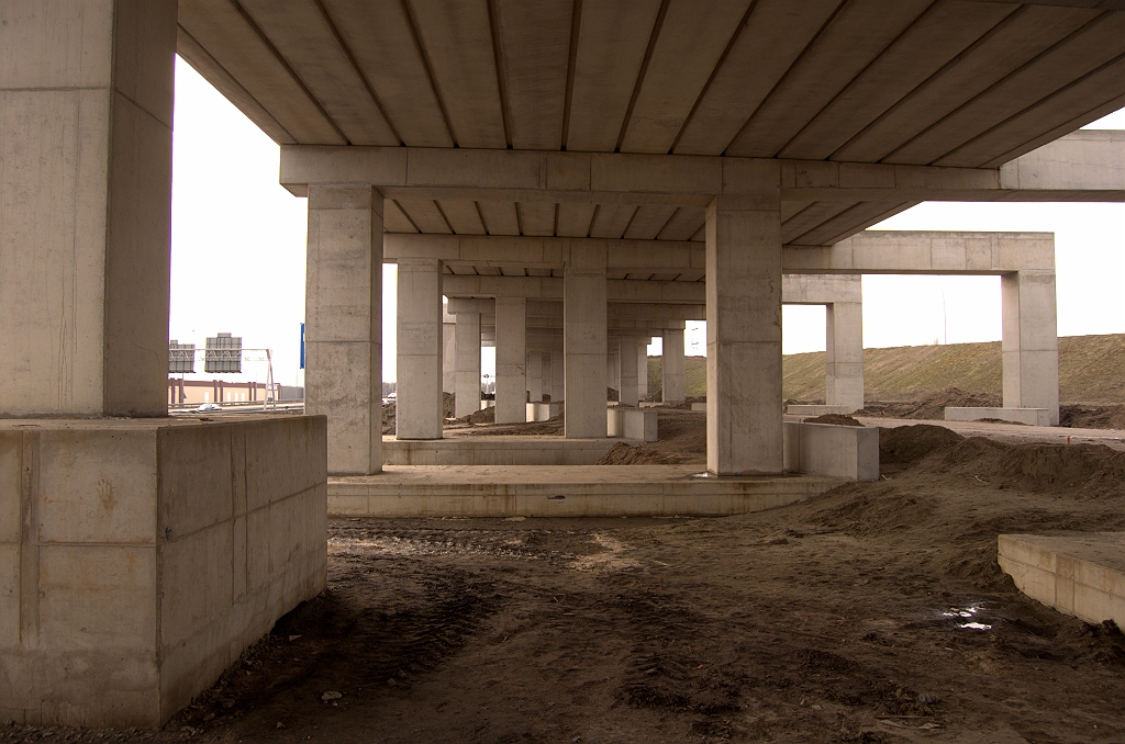 20090124-144408.jpg - Pergolafunderingen in KW 2 nog niet begraven. Ook de betonnen muurtjes aan weerszijden van de verbindingsweg Nijmegen-Maastricht, waar geleiderail op gemonteerd wordt, zullen goeddeels onder het maaiveld verdwijnen.
