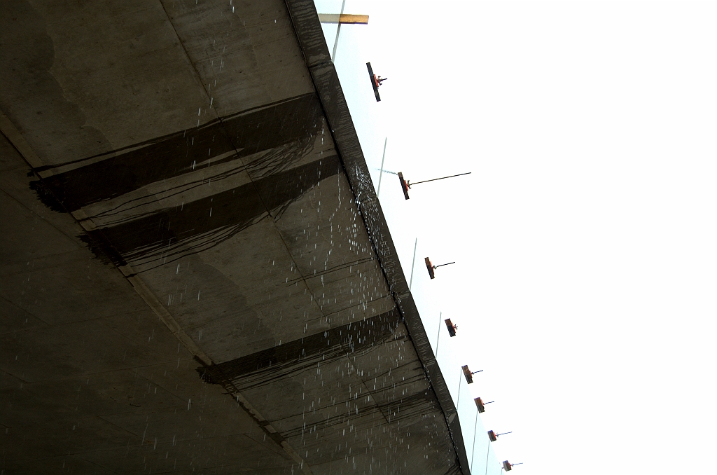 20090712-160635.bmp - Regenwater stroomt naar het verkantingsgewijs laagst gelegen punt op het viaduct. De betonnen zijprofielen zijn nog niet afgemonteerd, waardoor het vocht zich vervolgens op de A50 stort.