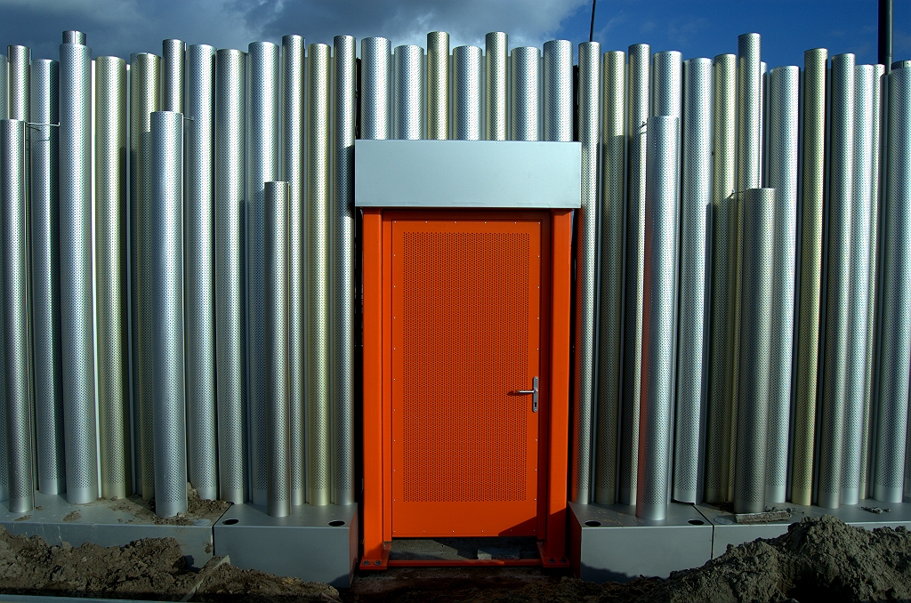 20091025-160419.bmp - De architect heeft dus beschikt dat een geperforeerde oranje vluchtdeur harmonieert met de eveneens geperforeerde aluminium buizen.