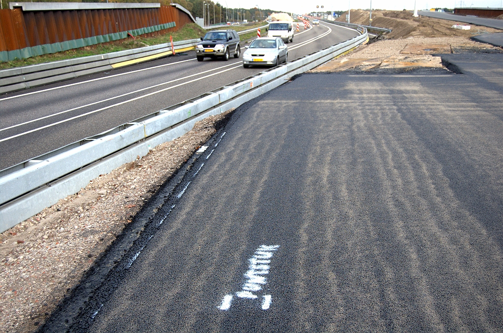 20091025-174719.bmp - Rijbaan inclusief ZOAB tot strak tegen de barrier aangelegd. "Puntstuk" is er op het wegdek gespoten.