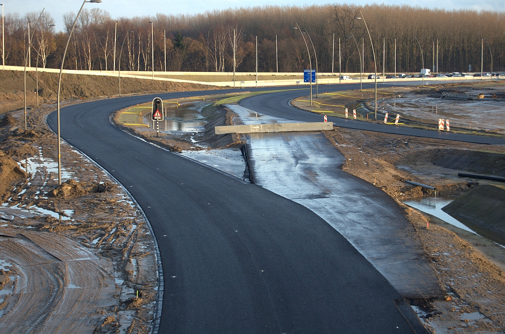 20091205-162731.bmp - Vervolg van de verbindingsweg Nijmegen-Woensel tussen KW 42 en het bestaande VRI geregelde kruispunt met de A58. Voor de aanstaande fasering is reeds een waarschuwingsknipperlicht voor de verkeerslichten geplaatst. Voor toekomstige faseringen is oversteekasfalt aangelegd naar de verbindingsweg Breda-Woensel.