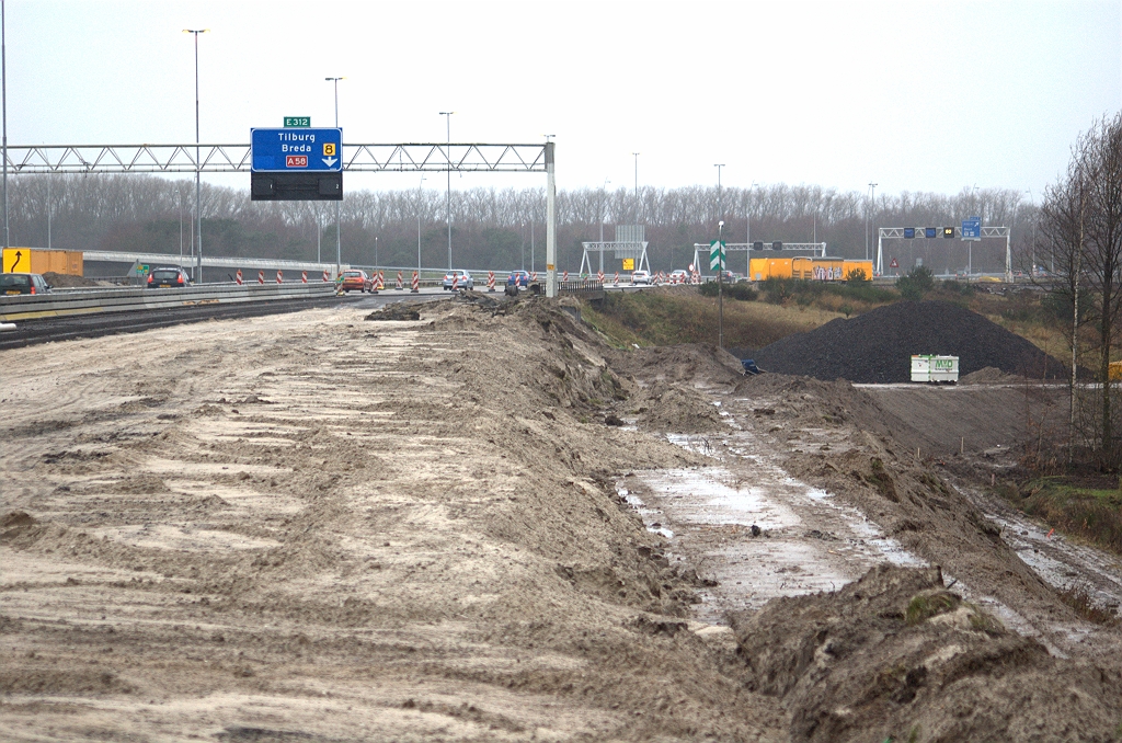20091206-151822.bmp - De Heijmans zandbazen hebben zelfs al een gedeelte van het vrijkomende dijklichaam afgegraven zodat de tijdelijke afdaling naar de oude verbindingsweg Maastricht-Breda verder kan worden aangelegd. Het verkeer links in de foto kan daar dan op worden overgezet zodat er werkruimte onstaat voor de aanleg van de parallelrijbaan in zuidelijke richting, en het oude viaduct (KW A) kan worden gesloopt.