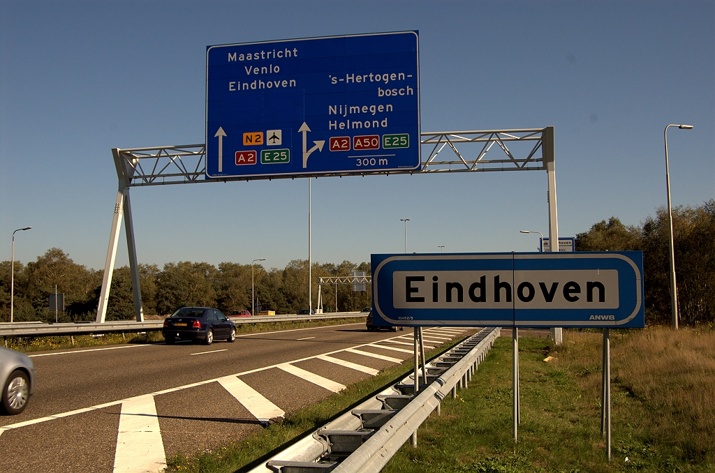 20101010-152759.bmp - Over naar de A58 vanuit de richting Tilburg. Eindhoven was hier al vermeld, maar met de toevoeging "-Centrum", die is verwijderd. Samen met het afdekken van "Randweg N2" levert dat veel vacant blauwvlak op. Het vervangende N2 schildje, en het toegevoegde vliegveldsymbool passen nog gemakkelijk tussen de pijlen. Aardig ook dat het vliegtuig in de aangegeven richting "vliegt". Agglomeratiebord wederom gehandhaafd.  week 201017 